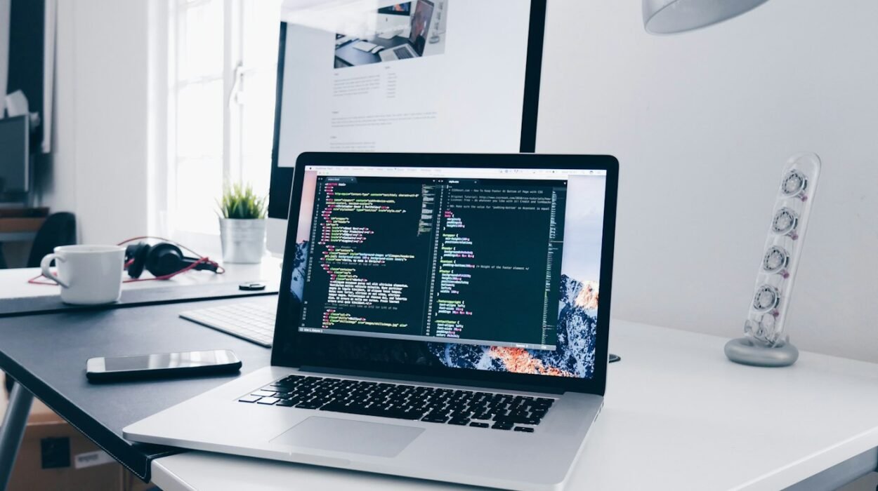 Laptop showing website code on a desk